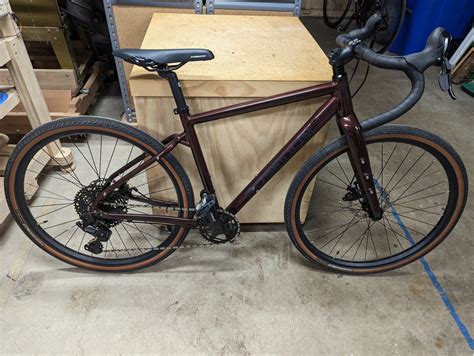 An aluminum frame gravel bike with upper mid-range components and mechanical disc brakes. . Poseidon redwood drop bar